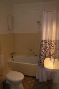 een badkamer met een toilet, een bad en een wastafel bij Ferienwohnung da Luz in Travemünde