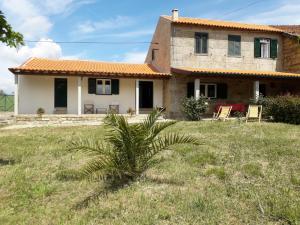 ein Haus mit einer Palme davor in der Unterkunft Casa da Farmácia in Castanheiro