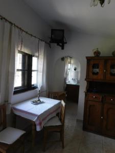 a room with a table and a window and a kitchen at Babamúzeum kis apartman in Tihany