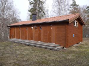 ein großes Holzgebäude mit einem Dach in der Unterkunft Café Björnen in Västerås