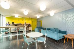 une salle d'attente avec des chaises et des tables ainsi qu'une cuisine dans l'établissement Aparthotel Adagio Access Paris Reuilly, à Paris