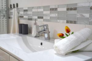 a white bathroom sink with a white towel on it at W&ouml;r&ouml;smarty Studio - Budapest Center in Budapest