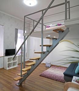 a metal staircase in a living room with a couch at W&ouml;r&ouml;smarty Studio - Budapest Center in Budapest
