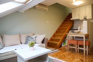 a living room with a couch and a staircase at Hann Apartments in Novi Sad