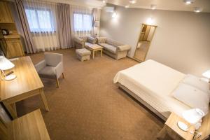 a hotel room with a bed and a living room at Hotel i Restauracja Pod Szyszkami in Krotoszyn