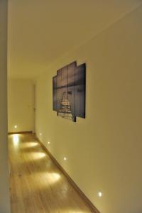 Bella Vacanza Limone في ليموني سول غاردا: غرفة بها لوحة على الحائط وارضية خشبية