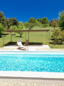 a pool with a gazebo and a table and a chair at Le Mas du Fort in Gargas