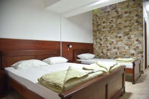 2 letti singoli in una camera con muro di mattoni di Hotel Galeb a Čanj