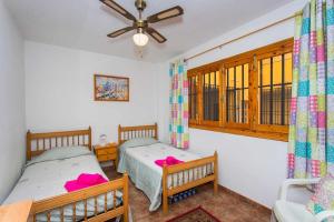sypialnia z dwoma łóżkami i wentylatorem sufitowym w obiekcie CH Vista Alegre Rocio del Mar w mieście Torrevieja