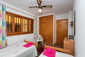 sypialnia z 2 łóżkami i krzyżem na ścianie w obiekcie CH Vista Alegre Rocio del Mar w mieście Torrevieja
