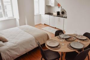 a bedroom with a bed and a table with chairs at Casa da Moeda by Escapadinha Portuguesa in Coimbra