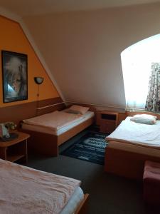 A bed or beds in a room at Romantik Étterem - Panzió
