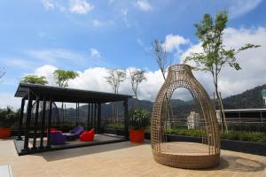 a wicker swing sitting on top of a roof at COMFORT & COZY HOME @ MIDHILLS GENTING in Genting Highlands