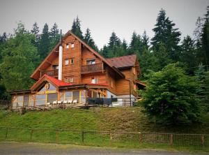 une grande maison en bois au sommet d'une colline dans l'établissement Penzión Racibor, à Oravský Podzámok