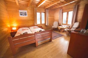 ein Schlafzimmer mit einem Bett in einer Holzhütte in der Unterkunft Penzión Racibor in Oravský Podzámok