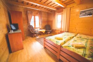 ein Schlafzimmer mit einem Bett in einer Holzhütte in der Unterkunft Penzión Racibor in Oravský Podzámok