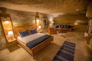 ギョレメにあるAzure Cave Suites - Cappadociaのベッドルーム1室(ベッド1台、ソファ付)