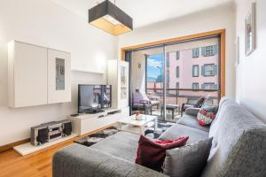 uma sala de estar com um sofá e uma televisão em Miramar Apartment with pool by HR Madeira no Funchal