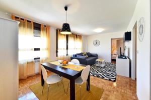 a dining room and living room with a table and chairs at Apartment Place4U in Zagreb