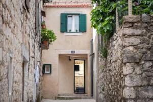 an alley between two buildings with a green window at No.5 Luxury Studio in Split