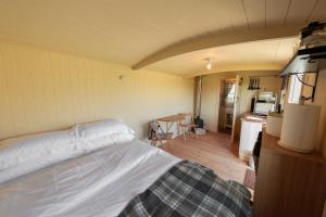 ein Schlafzimmer mit einem Bett und eine Küche mit einem Tisch in der Unterkunft Avon Riverside Glamping in Warwick