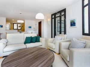a living room with white furniture and a wooden table at TarracoHomes, Villa with Botanic Garden and Private Pool facing the Beach in Miami Platja +19 photos