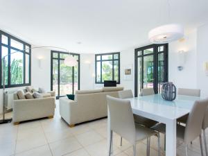a dining room with a white table and chairs at TarracoHomes, Villa with Botanic Garden and Private Pool facing the Beach in Miami Platja