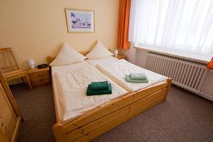 a bedroom with a wooden bed with two green pillows at Haus Panorama in Sankt Andreasberg