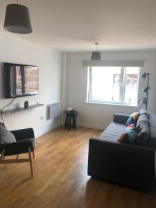 Quayside Apartment in Cardiff Bay في كارديف: غرفة معيشة مع أريكة وكرسي
