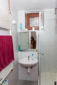 y baño blanco con lavabo y ducha. en Brunarica Čontoš, en Lendava