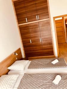 バラトンフレドにあるJacht Apartmanokのベッドルーム1室(ベッド2台、木製クローゼット付)