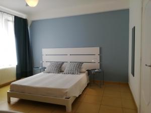 1 dormitorio con 1 cama blanca grande y 2 almohadas en B&B Dalla Nonna, en Mattinata