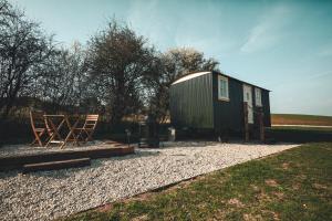 a green tiny house sitting on top of gravel at Avon Riverside Glamping in Warwick