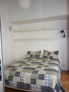 un letto con due cuscini in una camera bianca di Excelente departamento en Retiro a Buenos Aires
