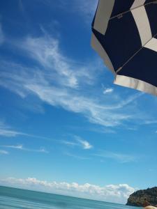 a beach with an umbrella and the ocean at B&B Dalla Nonna in Mattinata