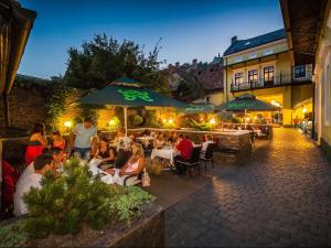 a group of people sitting at a restaurant at night at Hotel Central Park Sighisoara in Sighişoara