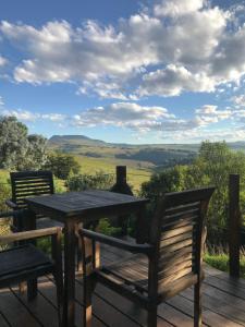 a wooden bench sitting on top of a lush green hillside at Over the Edge Cottage in Underberg