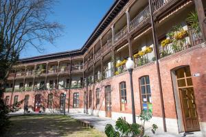 a large brick building with flowers on the balconies at Espacios Blanco Plaza del Viejo Coso in Valladolid