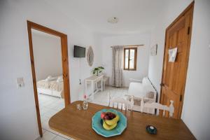 a room with a table with a bowl of fruit on it at Irene Komos in Pitsidia