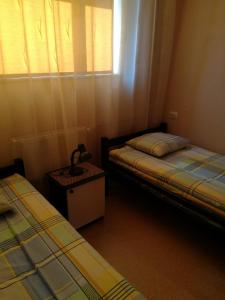 2 camas en una habitación pequeña con ventana en Brīvdienas en Alūksne