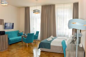 a bedroom with a bed and a couch and a table at Kosmopolita Apartments in Kraków