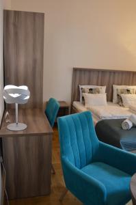 sypialnia z niebieskim krzesłem, łóżkiem i stołem w obiekcie Kosmopolita Apartments w Krakowie