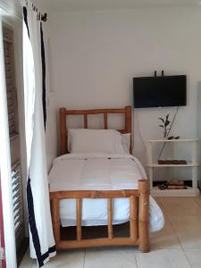 a bedroom with a wooden bed with white sheets at Point Village Negril in Negril