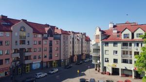 uitzicht op een straat met gebouwen en auto's bij Silver Apartaments in Piła