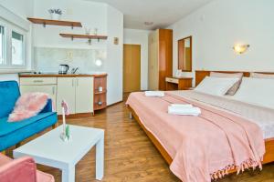 a bedroom with a large bed and a blue couch at Apartments Bubalo in Hvar