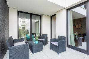 taras z wiklinowymi krzesłami i stołem w obiekcie Naviflat- Luxury Sopot Residence Okrzei 21 by Lion Apartments w mieście Sopot