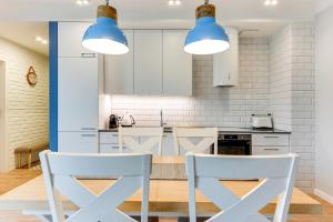 kuchnia z 2 białymi krzesłami i niebieskimi światłami w obiekcie Naviflat- Luxury Sopot Residence Okrzei 21 by Lion Apartments w mieście Sopot