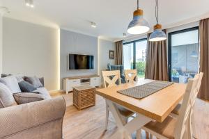 a living room with a dining room table and a couch at Lion Apartments - Naviflat Apartament Okrzei 21 in Sopot