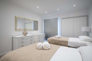 a bedroom with two beds and a mirror at Apartamento Pita by HR Madeira in Funchal