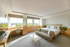 a bedroom with a bed and a couch and a desk at Royal Lancaster London in London